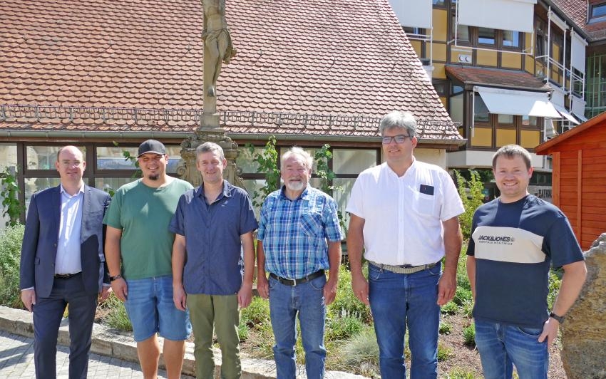 Mehrere Menschen stehen vor einer Dachfläche auf dem Boden